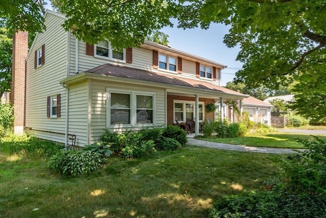 view of front of house featuring a front lawn, a chimney, and a porch