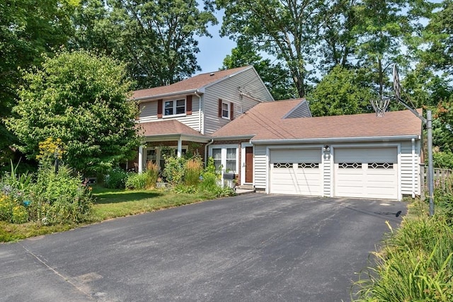 view of front of home featuring a garage, driveway, and roof with shingles