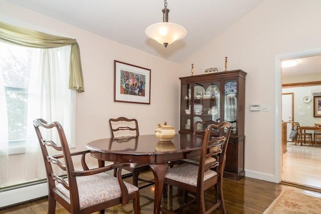 dining room with dark wood-type flooring, baseboards, vaulted ceiling, and baseboard heating