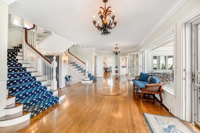 entryway featuring crown molding, hardwood / wood-style floors, and a chandelier