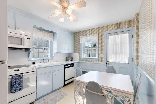 kitchen featuring white appliances, white cabinetry, and a sink