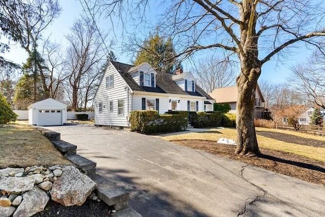 view of side of property featuring aphalt driveway, an outbuilding, and a garage