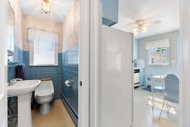 bathroom with toilet, tile walls, and a ceiling fan