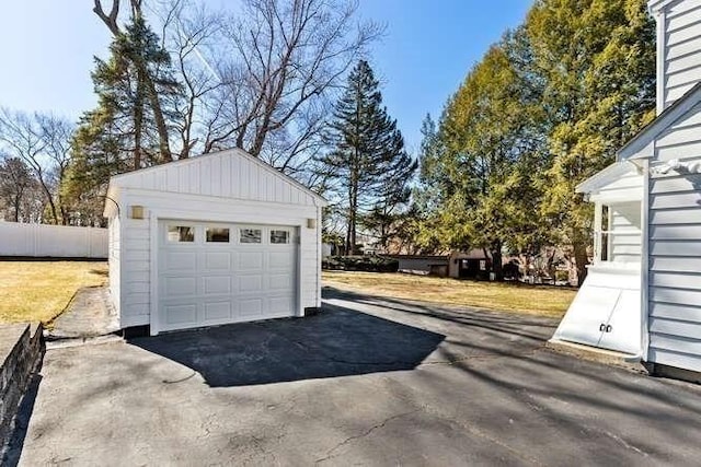 detached garage with fence and driveway