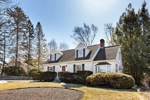 cape cod-style house featuring a front yard