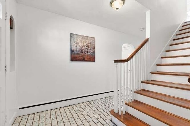 staircase featuring brick floor and a baseboard radiator