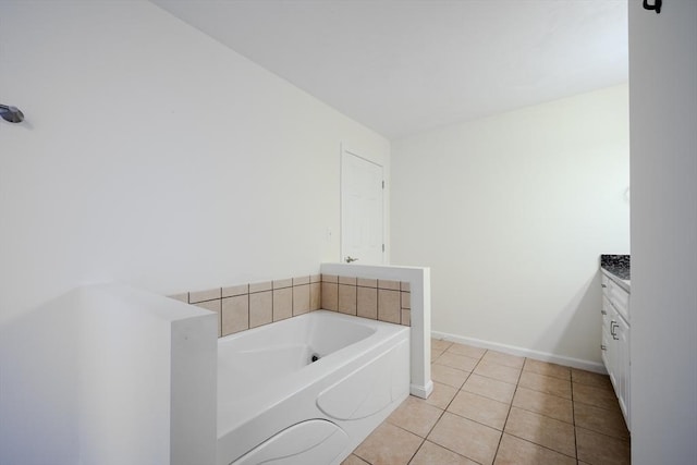 full bathroom with baseboards, tile patterned floors, vanity, and a bath