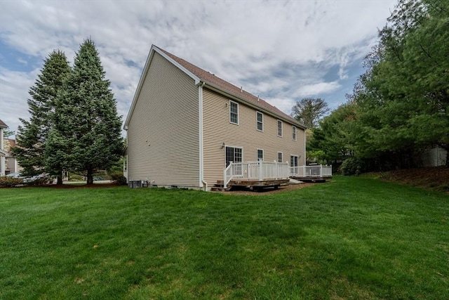 rear view of house with a lawn and a deck