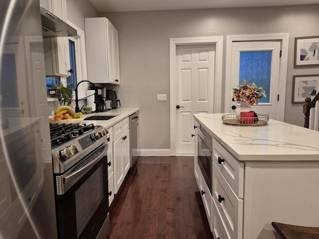 2 Neponset Pl, Canton, MA 02021 - kitchen with appliances with stainless steel finishes, dark wood-style flooring, a center island, light stone counters, and white cabinetry
