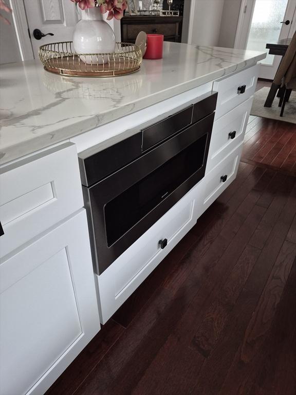 2 Neponset Pl, Canton, MA 02021 - kitchen view of dark wood-style flooring, white cabinets, and light stone countertops