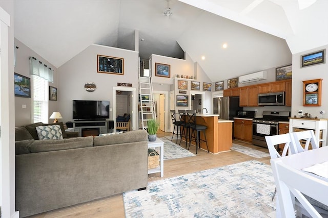 16 White Pine Knl Unit 199, Westford, MA 01886 - living area with high vaulted ceiling, an AC wall unit, and light wood-style floors