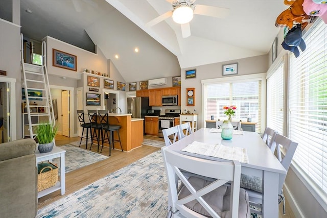16 White Pine Knl Unit 199, Westford, MA 01886 - dining area featuring a wall mounted air conditioner, high vaulted ceiling, ceiling fan, and light wood-style flooring
