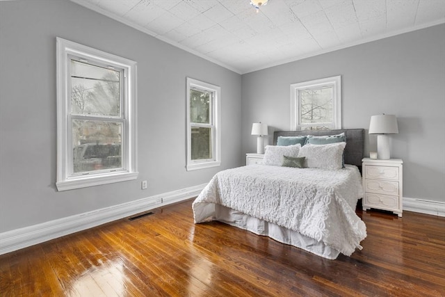 bedroom with multiple windows, ornamental molding, and dark hardwood / wood-style floors