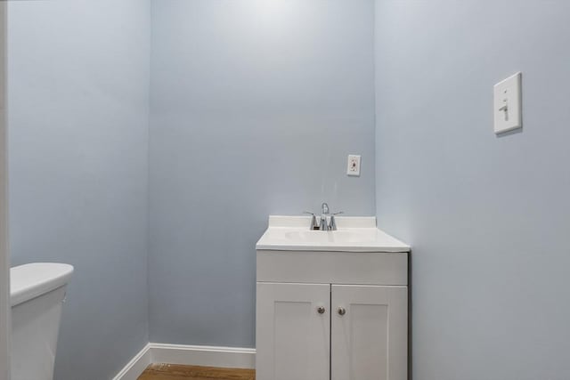 bathroom with vanity, wood-type flooring, and toilet