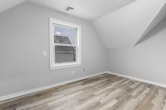 additional living space with lofted ceiling and light hardwood / wood-style floors