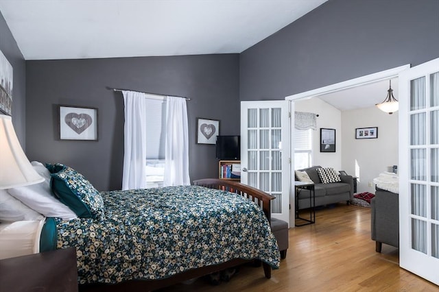 bedroom featuring vaulted ceiling, wood finished floors, and french doors