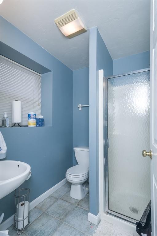 full bathroom with a shower stall, baseboards, toilet, and tile patterned flooring