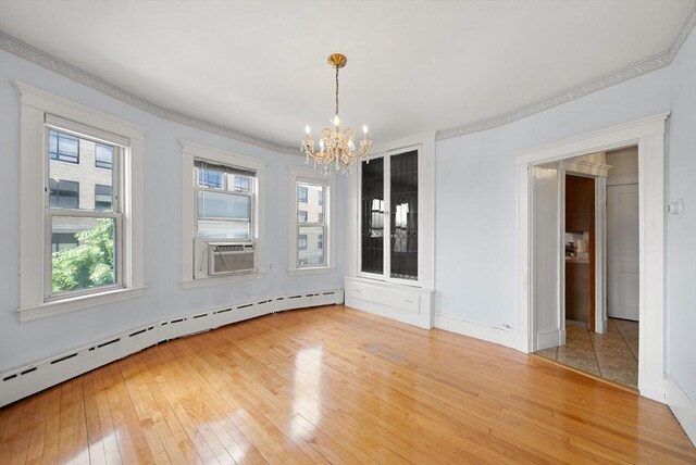 562 Broadway, Everett, MA 02149 - unfurnished dining area featuring a baseboard radiator, a chandelier, light wood-style flooring, cooling unit, and crown molding