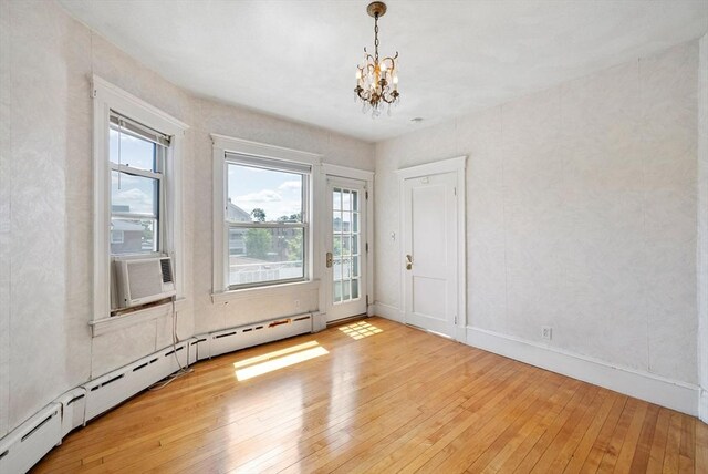 562 Broadway, Everett, MA 02149 - empty room featuring a baseboard radiator, light wood-type flooring, a chandelier, and cooling unit