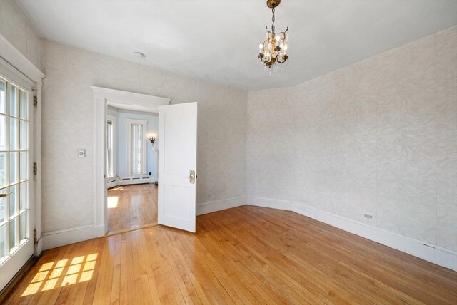 562 Broadway, Everett, MA 02149 - empty room featuring light wood-style floors, a chandelier, and baseboard heating