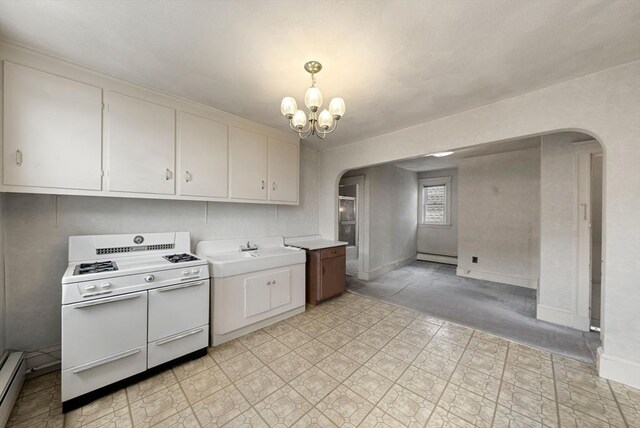 562 Broadway, Everett, MA 02149 - kitchen featuring arched walkways, range with two ovens, a chandelier, and light countertops