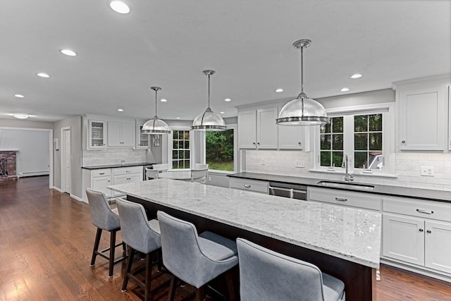 300 Maple St, Franklin, MA 02038 - kitchen featuring a sink, backsplash, plenty of natural light, a kitchen bar, and recessed lighting