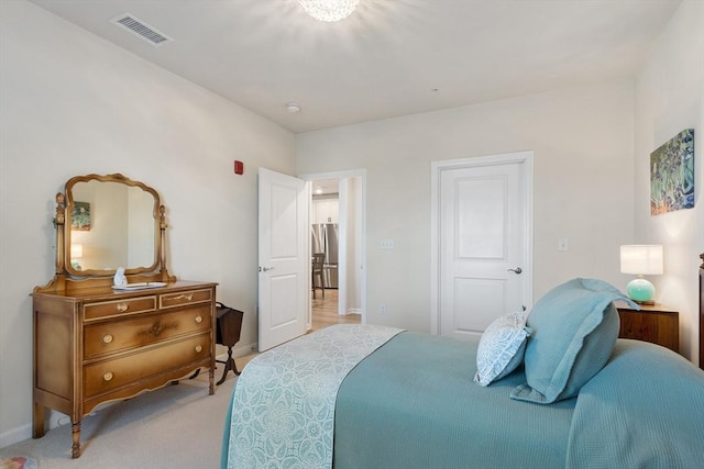 bedroom featuring light colored carpet and stainless steel refrigerator