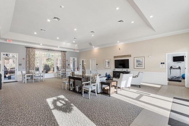 living room featuring a raised ceiling and crown molding