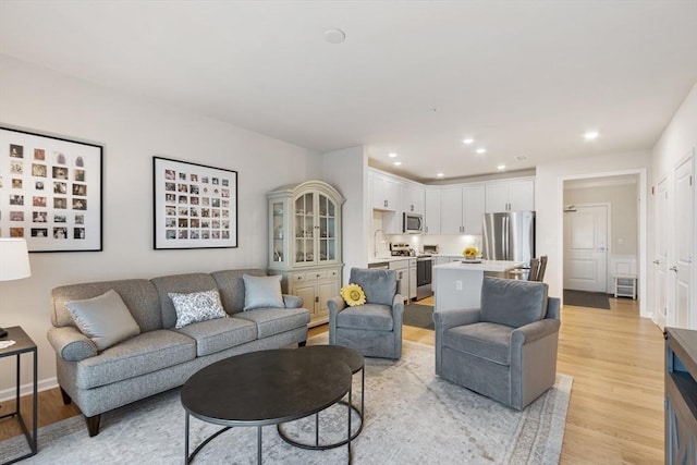 living room featuring light wood-type flooring and sink