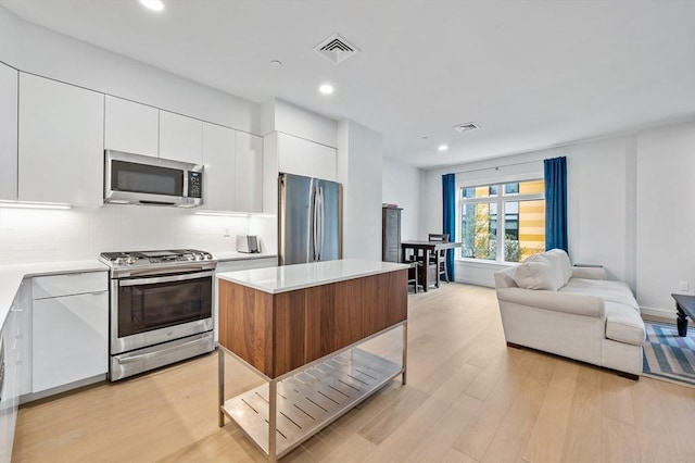 7 Lisbon St Unit 201, Boston, MA 02128 - kitchen featuring appliances with stainless steel finishes, modern cabinets, light wood-type flooring, white cabinetry, and light countertops