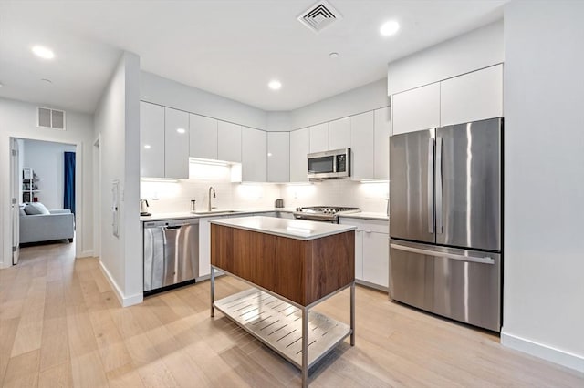7 Lisbon St Unit 201, Boston, MA 02128 - kitchen featuring stainless steel appliances, modern cabinets, white cabinetry, light countertops, and recessed lighting