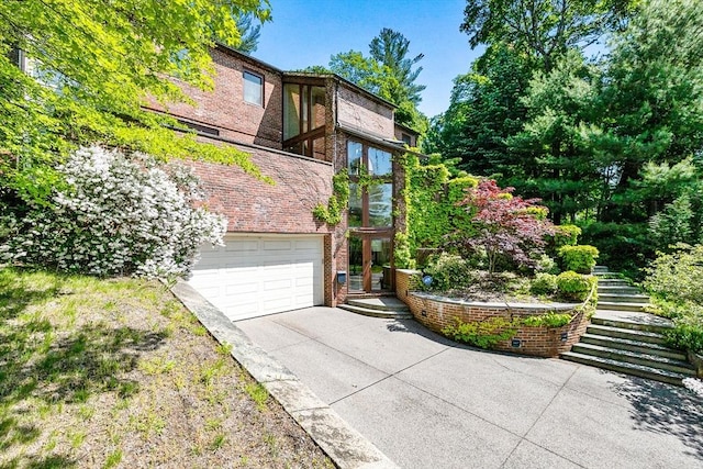 34 Lagrange St, Brookline, MA 02467 - view of front of property with driveway, stairway, a garage, and brick siding