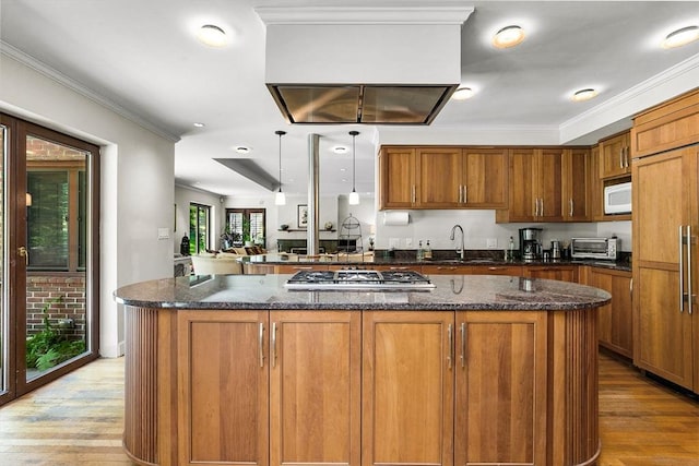 34 Lagrange St, Brookline, MA 02467 - kitchen featuring stainless steel gas stovetop, paneled built in fridge, brown cabinetry, and ornamental molding