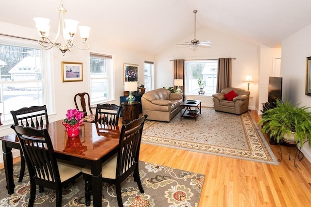 dining space with baseboards, a notable chandelier, wood finished floors, and vaulted ceiling