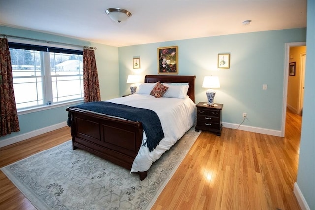 bedroom with baseboards and light wood finished floors