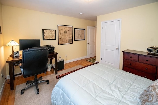 bedroom with baseboards and wood finished floors