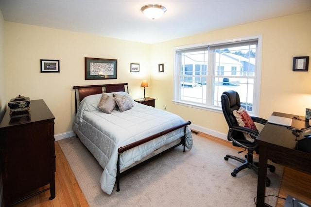 bedroom with baseboards and wood finished floors