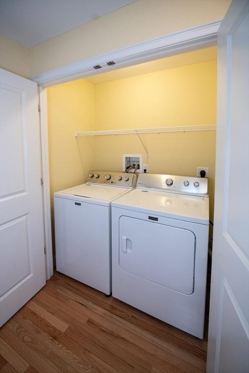 laundry area with laundry area, wood finished floors, and separate washer and dryer