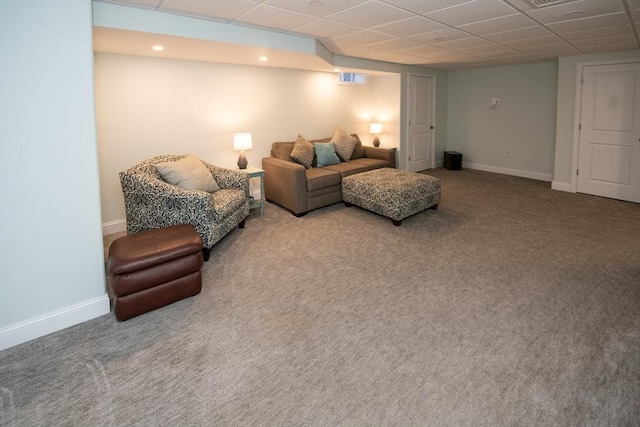 carpeted living room with visible vents, a paneled ceiling, and baseboards