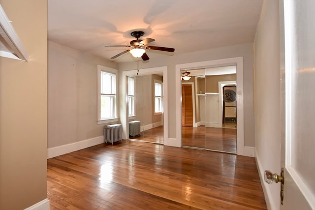 spare room featuring radiator heating unit, hardwood / wood-style flooring, and ceiling fan