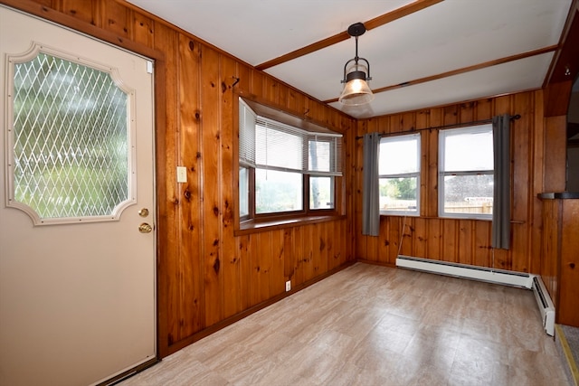 interior space with wood walls, a baseboard radiator, and plenty of natural light