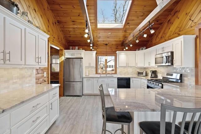 10 Chadwell Ave, Sandwich, MA 02563 - kitchen featuring wood ceiling, lofted ceiling with skylight, and stainless steel appliances