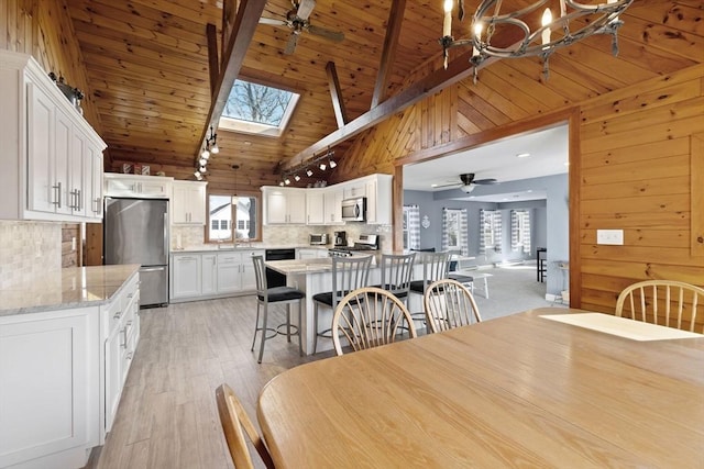 10 Chadwell Ave, Sandwich, MA 02563 - dining area featuring plenty of natural light, wooden walls, and ceiling fan with notable chandelier