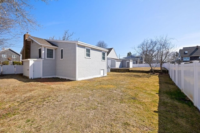 10 Chadwell Ave, Sandwich, MA 02563 - rear view of house with a chimney, a fenced backyard, and a lawn