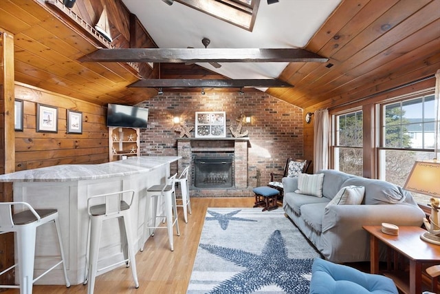 10 Chadwell Ave, Sandwich, MA 02563 - living room featuring brick wall, a fireplace, light wood-style floors, wood ceiling, and vaulted ceiling with beams