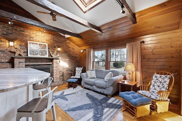 10 Chadwell Ave, Sandwich, MA 02563 - living room with brick wall, a fireplace, rail lighting, lofted ceiling with skylight, and wood finished floors