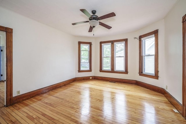 spare room with light wood-style flooring, baseboards, and a ceiling fan