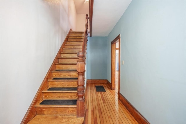 stairs featuring wood-type flooring and baseboards