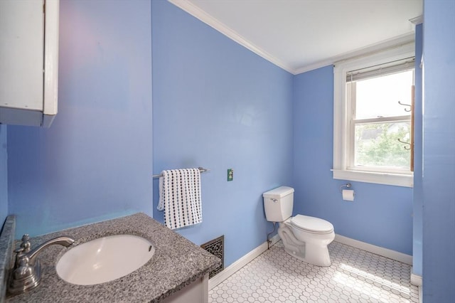bathroom featuring baseboards, toilet, ornamental molding, and vanity