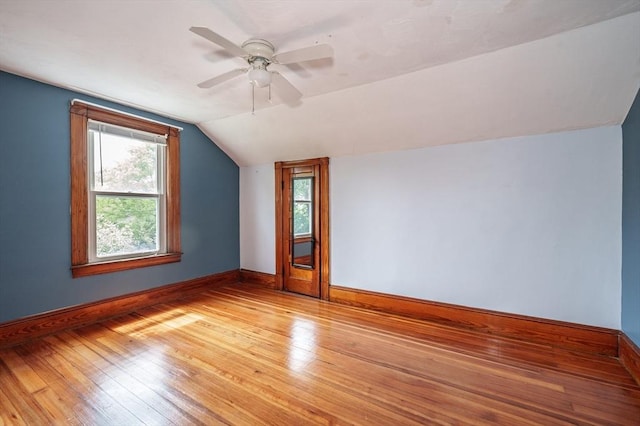 bonus room featuring lofted ceiling, light wood finished floors, baseboards, and a ceiling fan